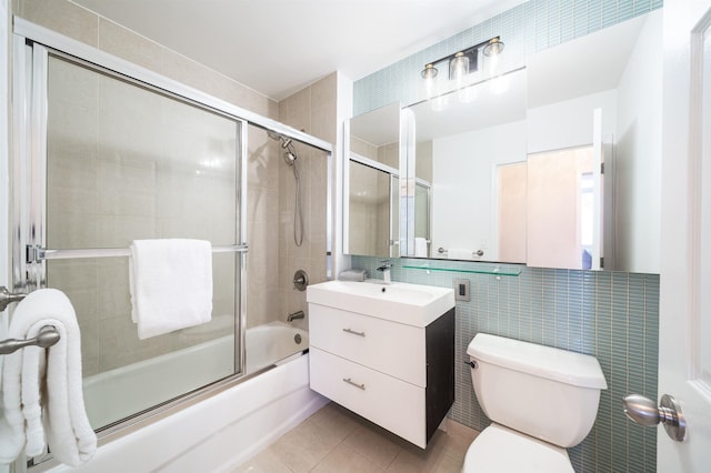 20 2nd St Unit 2503, Jersey City, NJ 07302 - bathroom featuring tile walls, bath / shower combo with glass door, vanity, toilet, and tile patterned floors