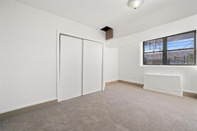 unfurnished bedroom featuring carpet floors, baseboards, and a closet