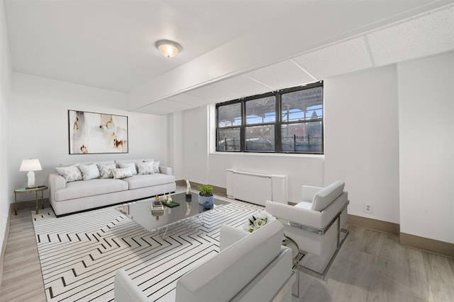 living room with radiator, light wood finished floors, and baseboards