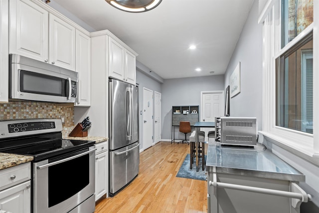 403 Monroe St Unit 3L, Hoboken, NJ 07030 - kitchen with appliances with stainless steel finishes, backsplash, white cabinets, light wood-style flooring, and recessed lighting