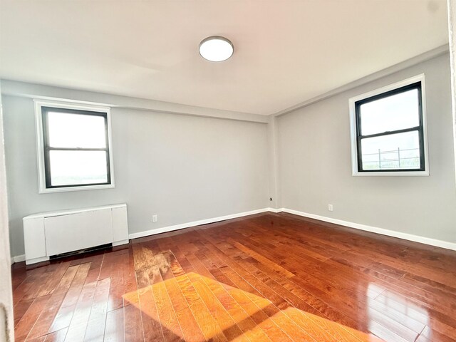 1225 Kennedy Blvd Unit 5E, Bayonne, NJ 07002 - spare room featuring wood-type flooring, radiator heating unit, and baseboards