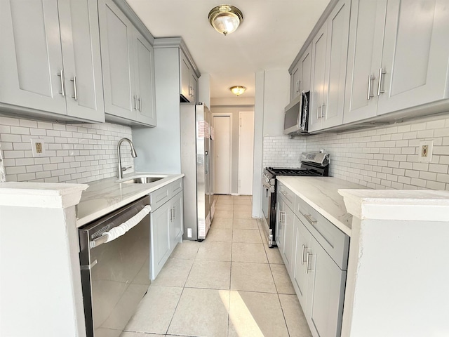 1225 Kennedy Blvd Unit 5E, Bayonne, NJ 07002 - kitchen featuring appliances with stainless steel finishes, gray cabinetry, a sink, light tile patterned flooring, and decorative backsplash
