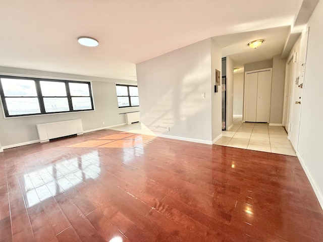 1225 Kennedy Blvd Unit 5E, Bayonne, NJ 07002 - empty room featuring radiator heating unit, light wood-type flooring, and baseboards