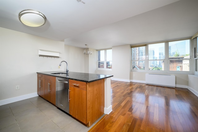 88 Morgan St Unit 802, Jersey City, NJ 07302 - kitchen with stainless steel dishwasher, brown cabinets, radiator heating unit, dark stone countertops, and a chandelier