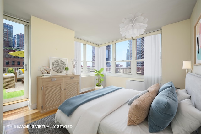 88 Morgan St Unit 802, Jersey City, NJ 07302 - bedroom featuring a city view, wood finished floors, multiple windows, and a chandelier