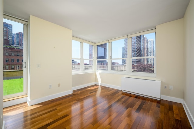 88 Morgan St Unit 802, Jersey City, NJ 07302 - unfurnished room with a city view, radiator, wood finished floors, and healthy amount of natural light