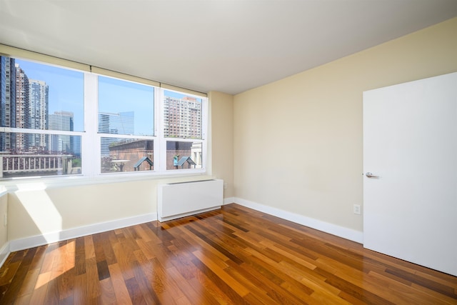 88 Morgan St Unit 802, Jersey City, NJ 07302 - empty room with a view of city, wood finished floors, and radiator