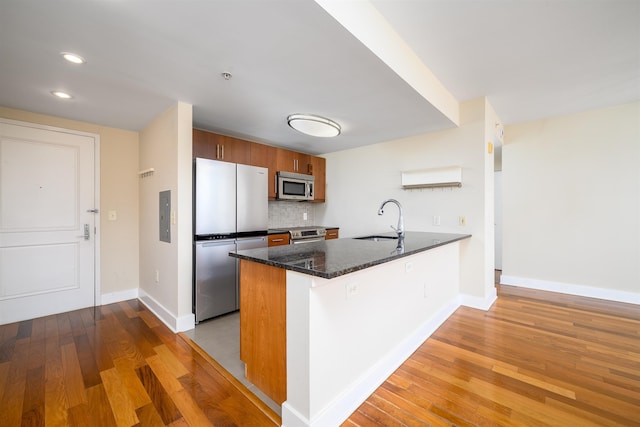 88 Morgan St Unit 802, Jersey City, NJ 07302 - kitchen with stainless steel appliances, a peninsula, decorative backsplash, wood finished floors, and recessed lighting