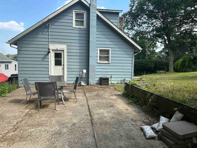 back of property with central AC unit, a yard, and a patio area