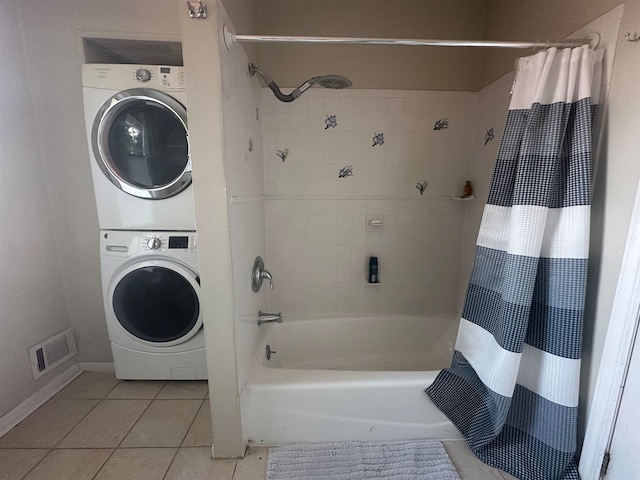 bathroom featuring stacked washing maching and dryer, shower / tub combo with curtain, and tile patterned floors