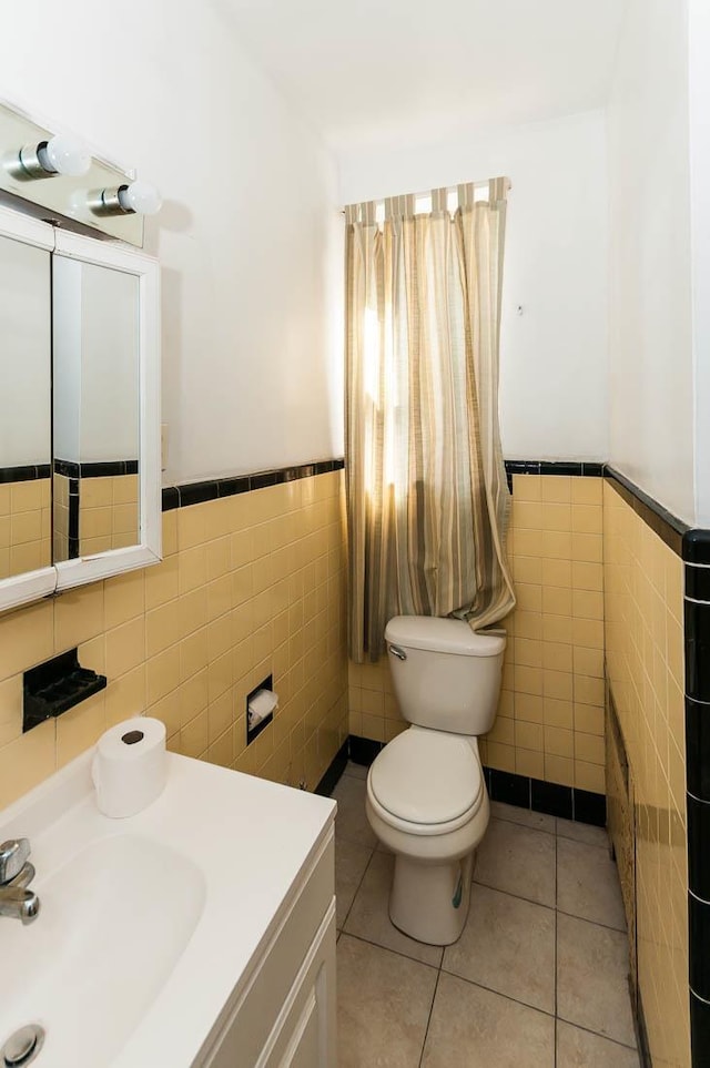 bathroom featuring tile patterned floors, toilet, tile walls, and vanity