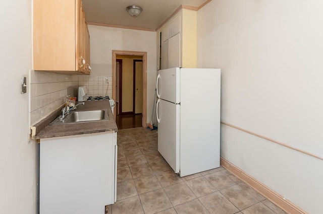 kitchen with light brown cabinetry, sink, backsplash, white appliances, and ornamental molding