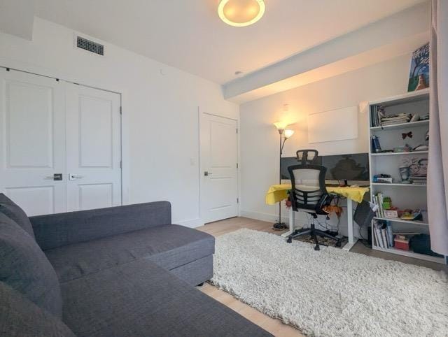 office area featuring light wood finished floors, visible vents, and baseboards