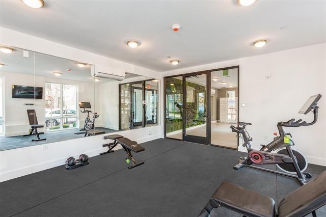 exercise room with baseboards and a wall mounted air conditioner