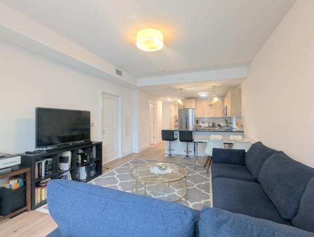 living area with light wood-type flooring and visible vents