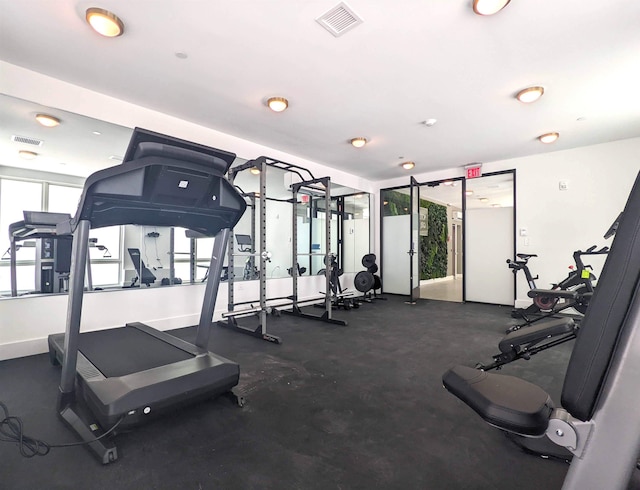 exercise room with baseboards and visible vents