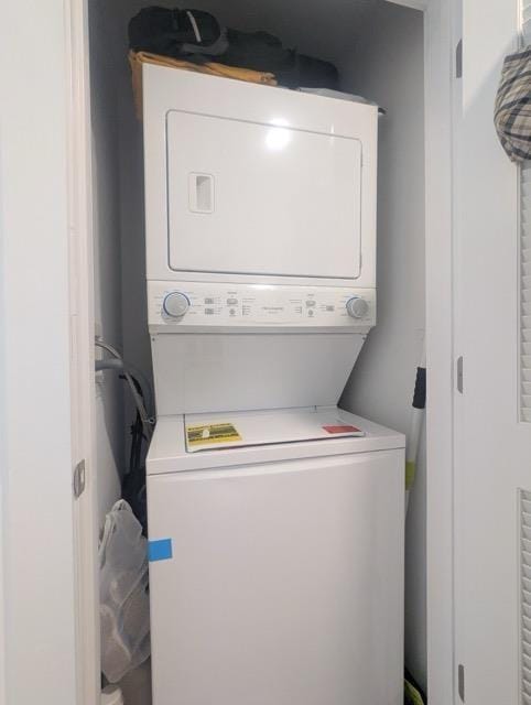 clothes washing area featuring stacked washer / drying machine