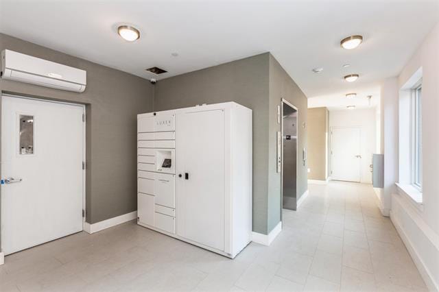 hallway with a wall unit AC and baseboards