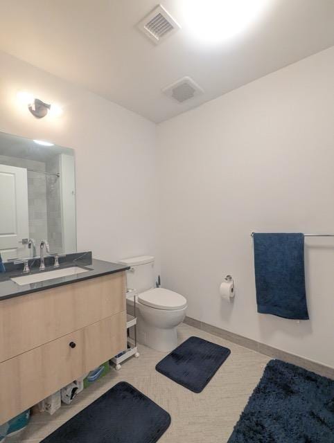 bathroom with tile patterned flooring, toilet, vanity, visible vents, and baseboards