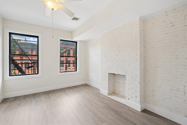 227 Bay St Unit 4B, Jersey City, NJ 07302 - unfurnished living room with brick wall, wood finished floors, and ceiling fan