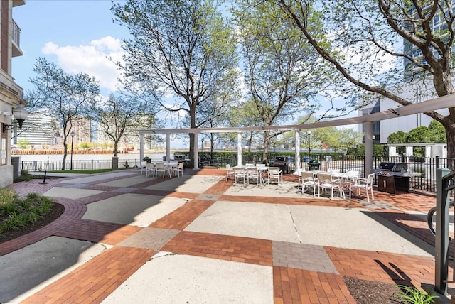 view of community featuring fence and outdoor dining area