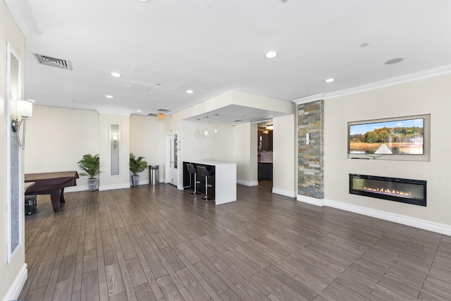 unfurnished living room featuring a glass covered fireplace, ornamental molding, recessed lighting, and visible vents