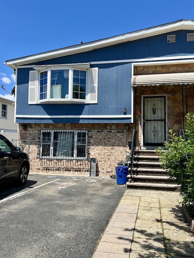 5 Chopin Ct, Jersey City, NJ 07302 - view of property featuring stone siding and uncovered parking