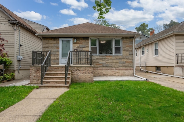 64 W 57th St, Bayonne, NJ 07002 - bungalow featuring stone siding, a front yard, and a shingled roof
