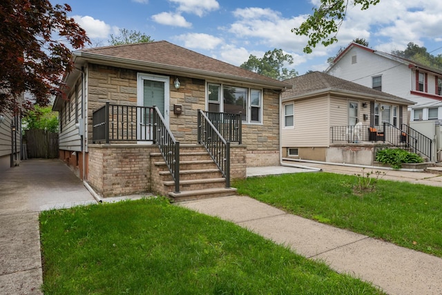 64 W 57th St, Bayonne, NJ 07002 - bungalow with stone siding, a front lawn, and roof with shingles