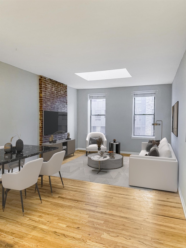 living room with a skylight and light hardwood / wood-style floors