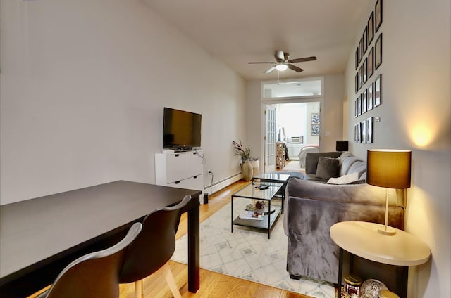 living room featuring hardwood / wood-style floors, ceiling fan, and a baseboard radiator