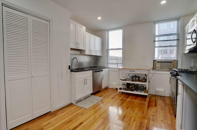 kitchen featuring white cabinets, sink, stainless steel appliances, and light hardwood / wood-style flooring