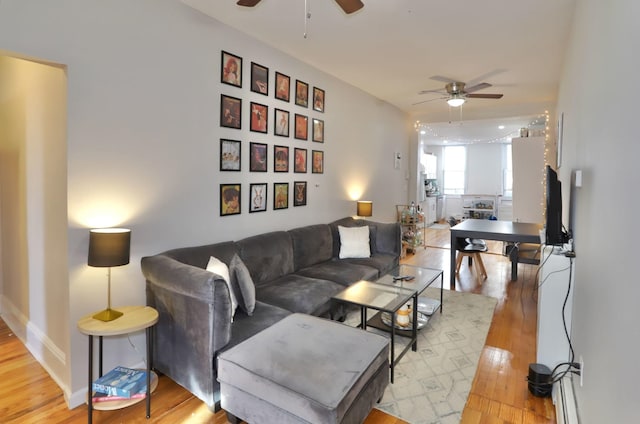 living room featuring ceiling fan and light hardwood / wood-style floors