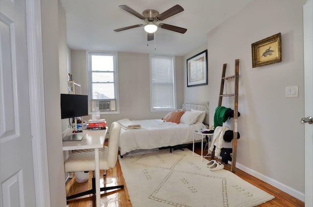 bedroom featuring wood-type flooring, ceiling fan, and cooling unit