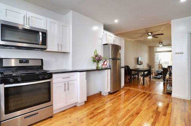 kitchen featuring stainless steel appliances, white cabinetry, ceiling fan, and light hardwood / wood-style floors