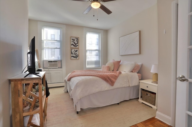 bedroom with a baseboard radiator, light parquet floors, ceiling fan, and cooling unit