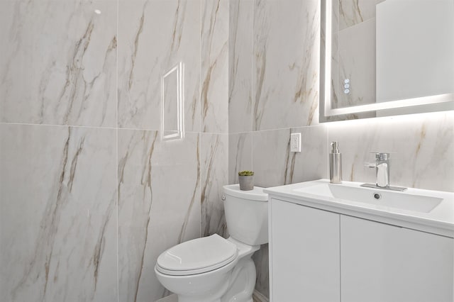 bathroom with tile walls, backsplash, vanity, and toilet