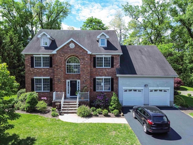 57 Terrace Ave, West Orange, NJ 07052 - view of front of home featuring asphalt driveway, a garage, a front lawn, and brick siding