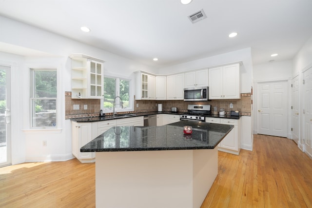 57 Terrace Ave, West Orange, NJ 07052 - kitchen featuring stainless steel appliances, a sink, white cabinetry, light wood finished floors, and backsplash