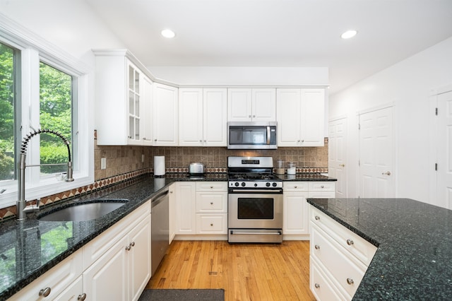 57 Terrace Ave, West Orange, NJ 07052 - kitchen with stainless steel appliances, a sink, white cabinets, glass insert cabinets, and light wood-type flooring