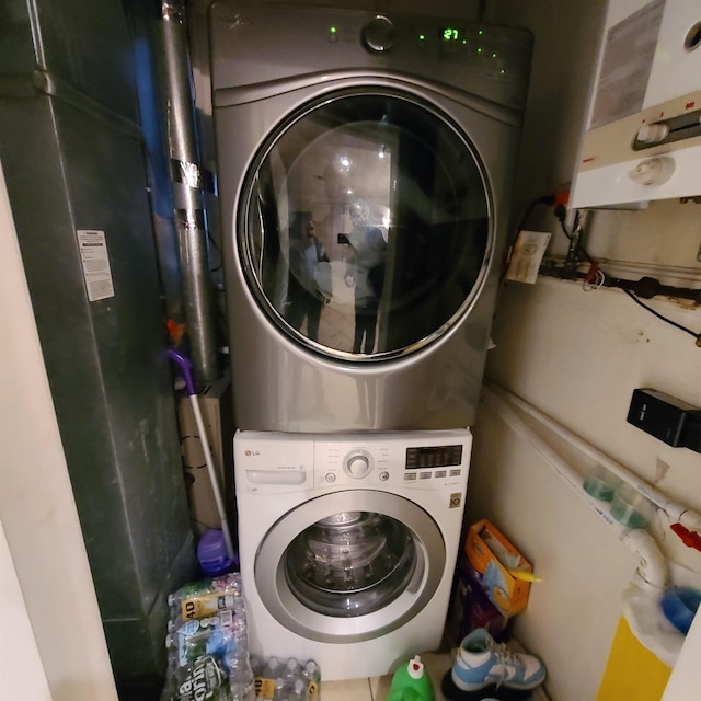 clothes washing area featuring stacked washer and clothes dryer