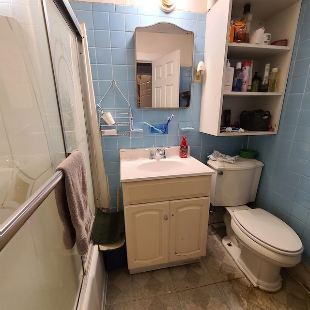 full bathroom featuring vanity, tile walls, and toilet