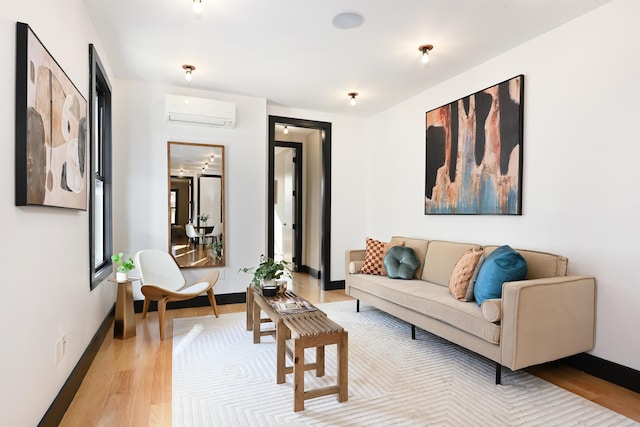 living room with light wood-style floors, baseboards, and an AC wall unit