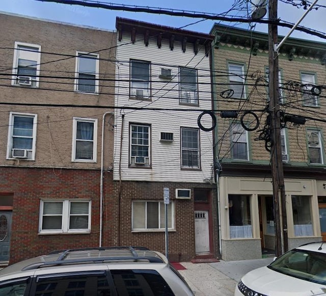 view of front facade featuring cooling unit and brick siding