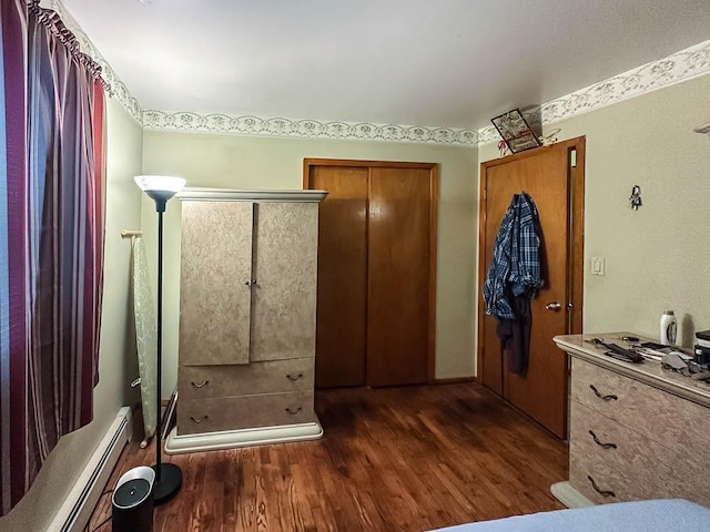 bathroom featuring a shower, baseboard heating, and wood finished floors