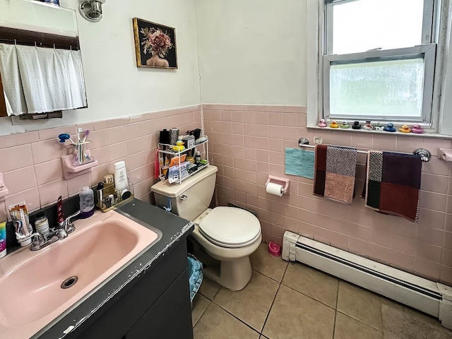bathroom featuring a wainscoted wall, a baseboard radiator, toilet, vanity, and tile patterned flooring