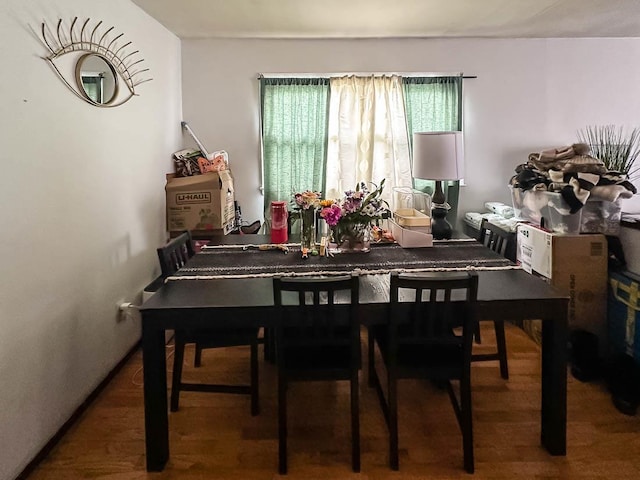 dining area with baseboards and wood finished floors