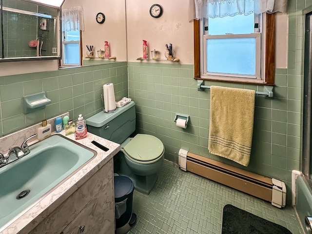 bathroom featuring tile walls, toilet, vanity, and baseboard heating