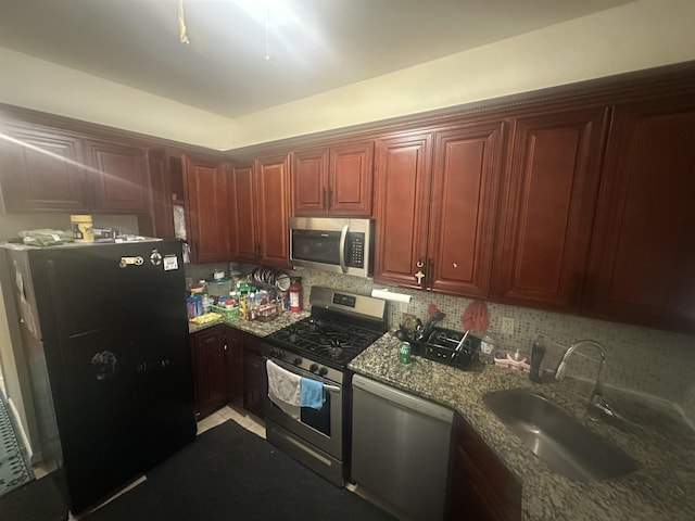 10 Clendenny Ave, Jersey City, NJ 07304 - kitchen with stone countertops, reddish brown cabinets, a sink, appliances with stainless steel finishes, and backsplash