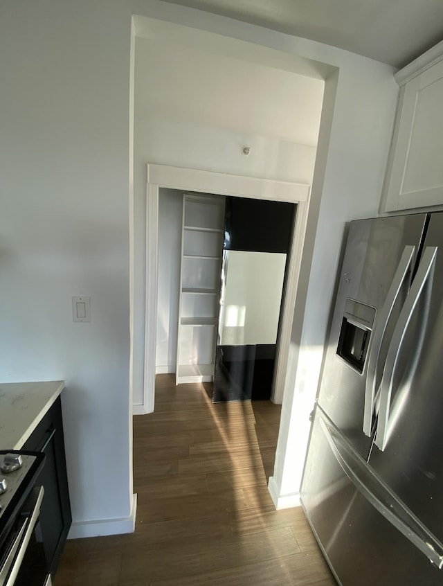 kitchen featuring dark wood finished floors, white cabinets, stainless steel appliances, and baseboards